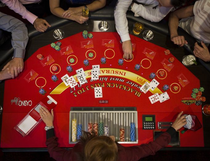 A group of people sitting around a table playing poker.