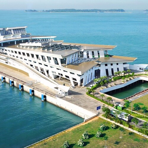 A large building on the water with a dock in front of it.