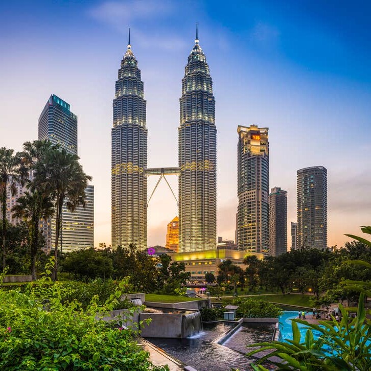 A view of the petronas twin towers from across the street.