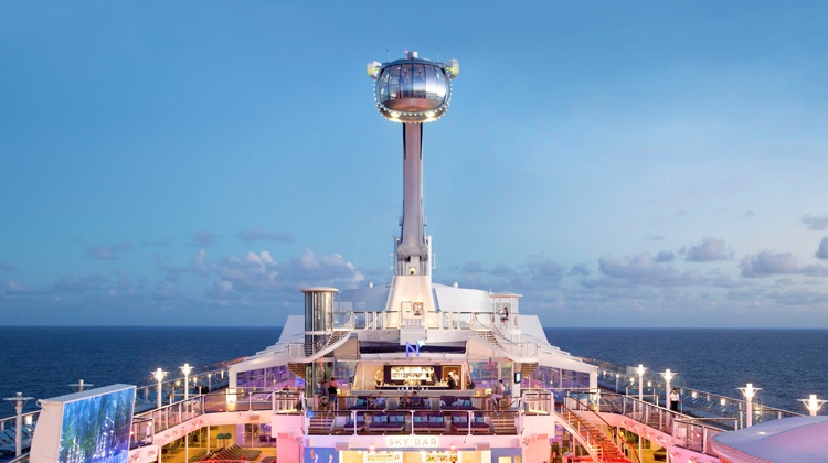 A large cruise ship with a tower in the background.