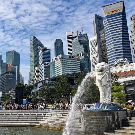 A fountain in front of a city skyline.