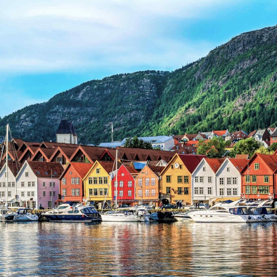 A row of houses on the side of a body of water.