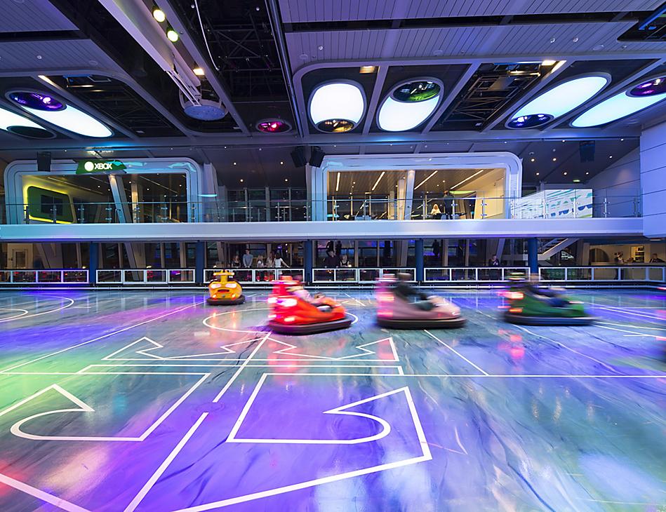 A group of people riding on the ground in bumper cars.