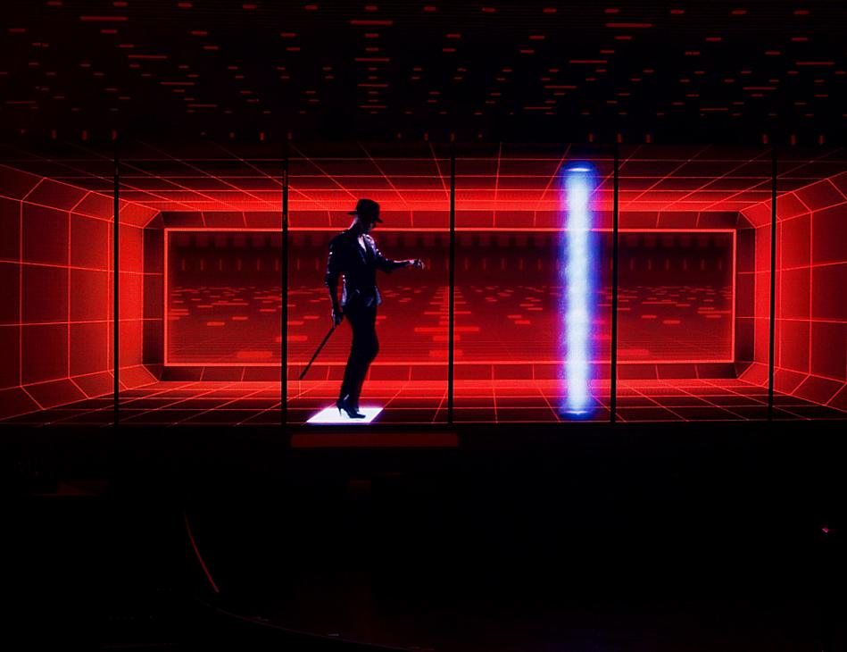 A man standing in front of a wall with lights.