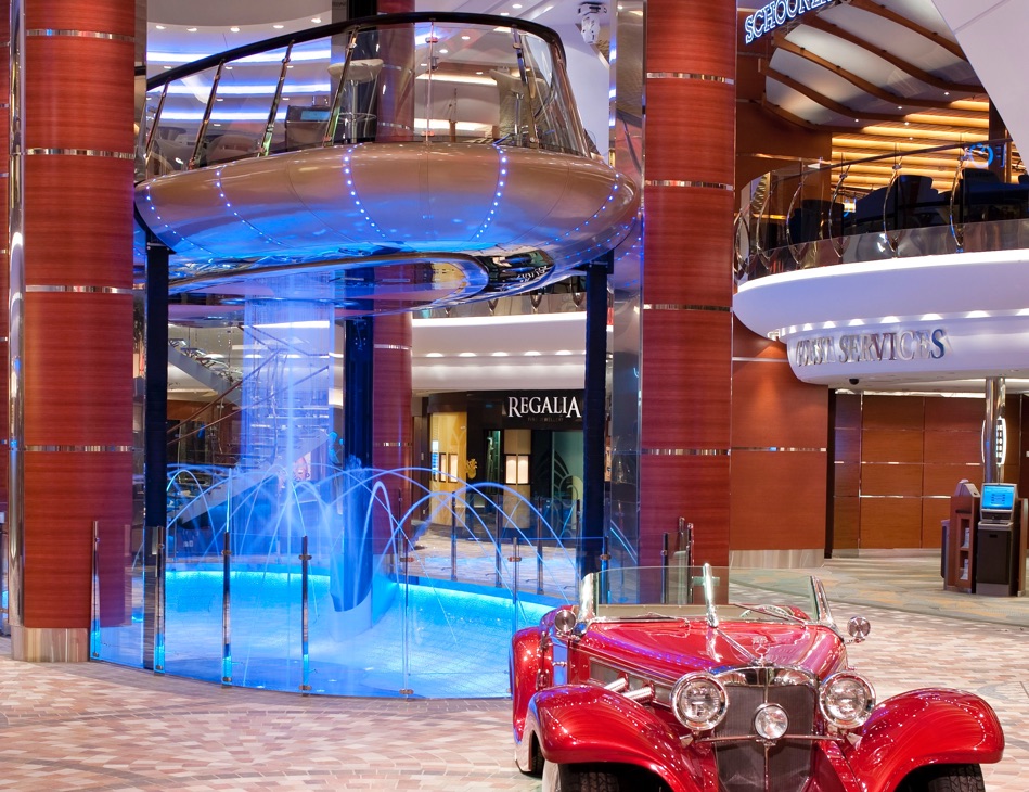 A car parked in front of a fountain inside a building.