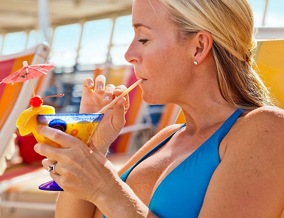 A woman in blue shirt holding a drink.