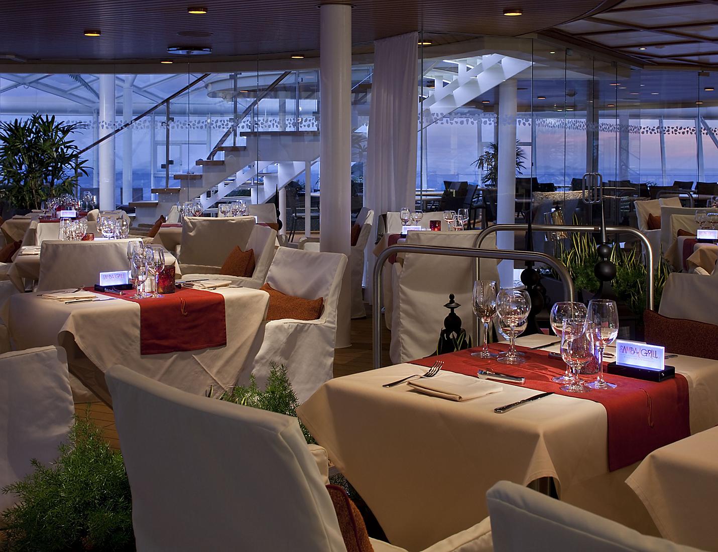 A restaurant with tables and chairs set up for dinner.