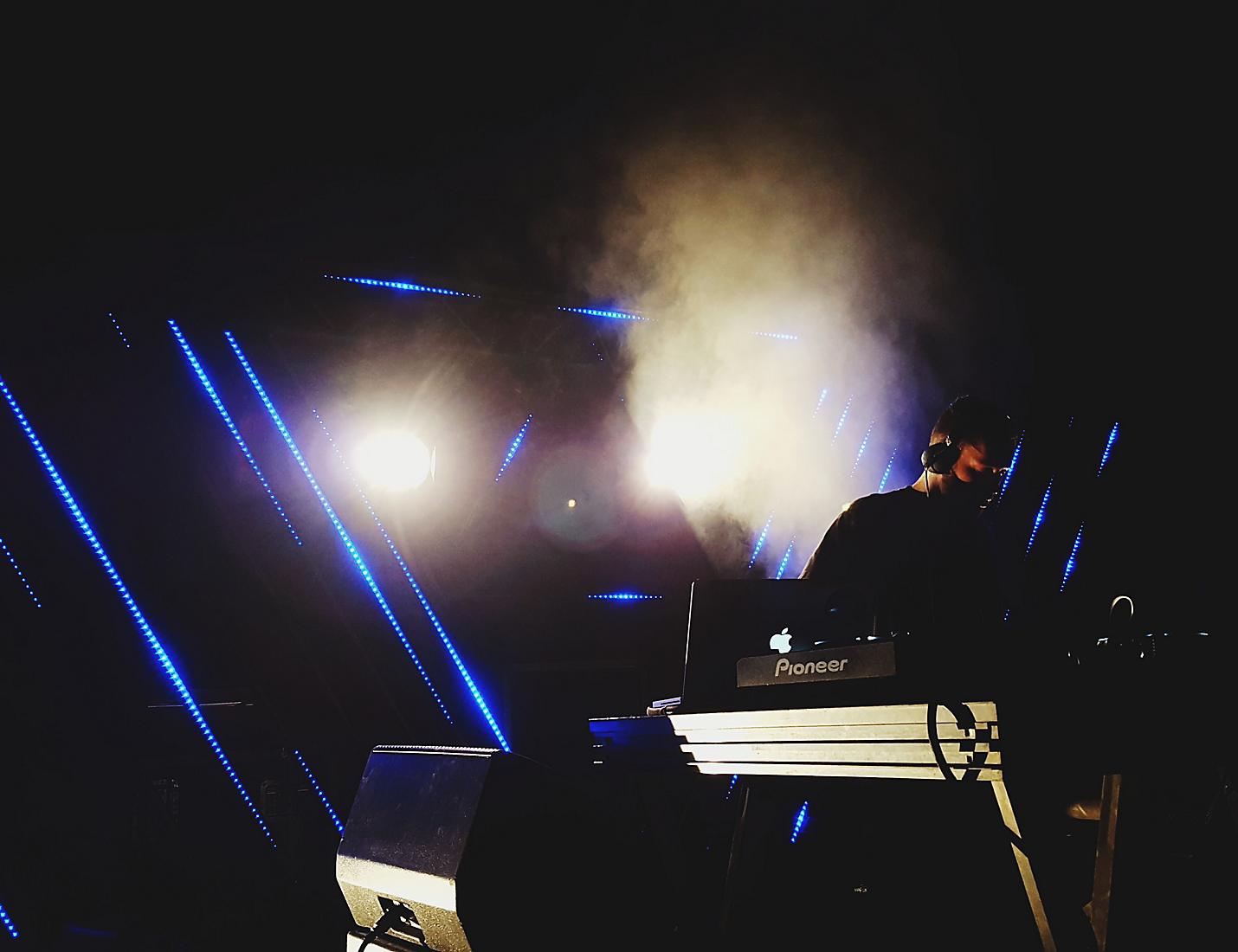 A person sitting on top of a stage with lights.