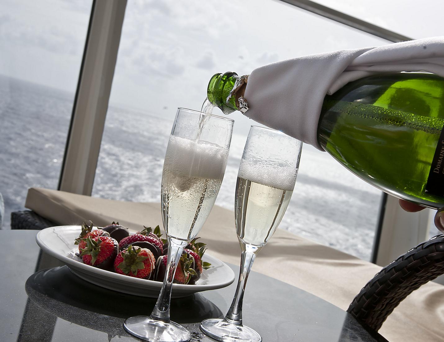 A person pouring champagne into two glasses.