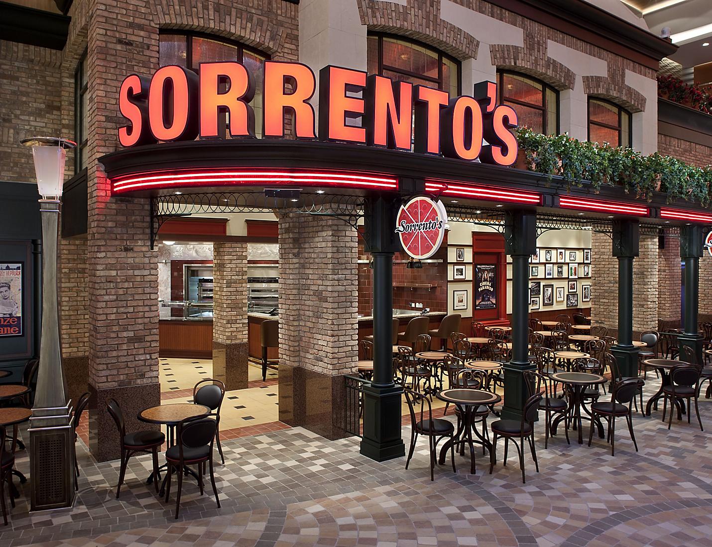 A restaurant with tables and chairs outside of it.