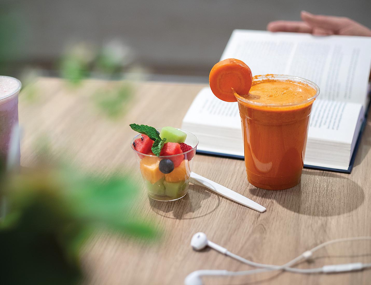 A table with an orange juice and fruit in it.