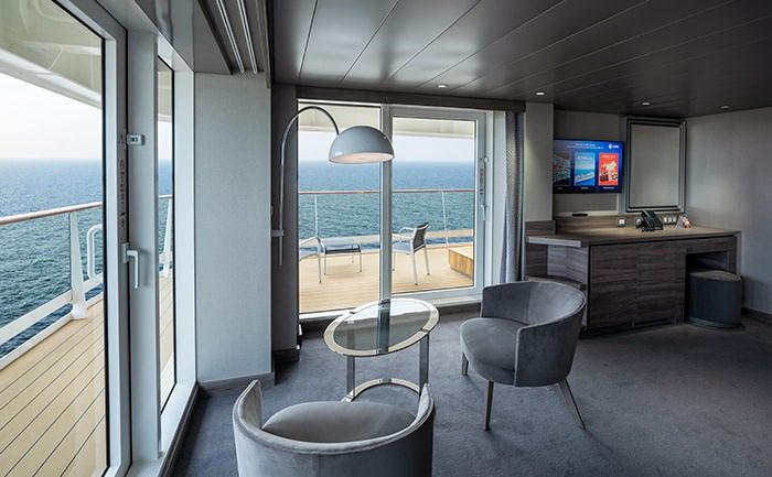 A room with a view of the ocean and a balcony.